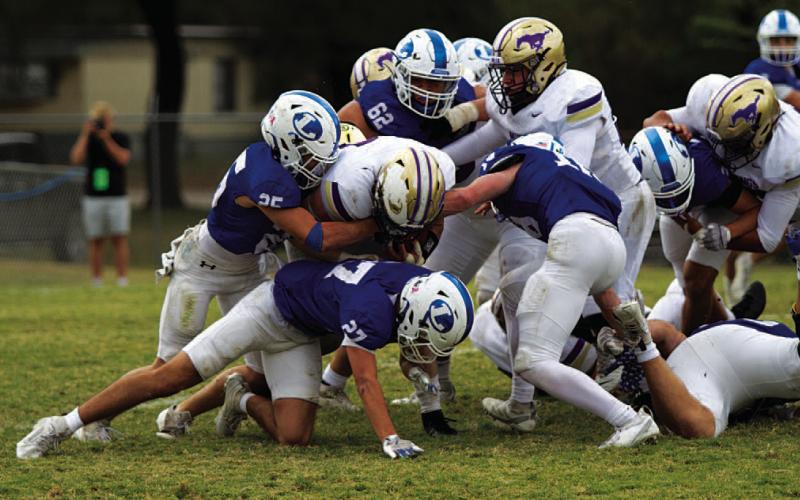 A group of Badgers are in on a tackle for loss against the Mustangs. HUNTER KING | DISPATCH RECORD