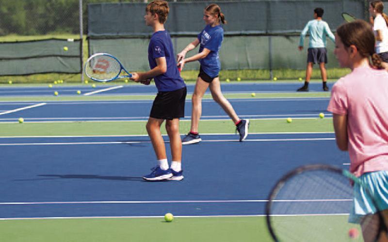 HUNTER KING | DISPATCH RECORD Young tennis players work on their shots during camp on Tuesday.