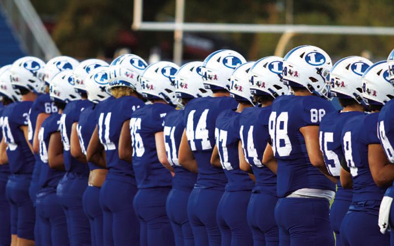The Badger football team lines up before every game as the coin is tossed to begin each contest. HUNTER KING | DISPATCH RECORD