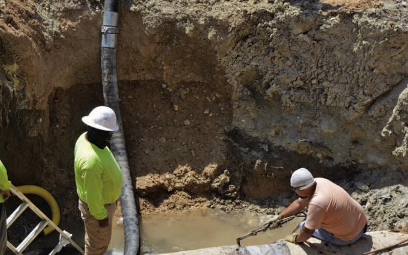 KWSC employees work to repair the leak in the transmission line on Friday afternoon. ERICK MITCHELL | DISPATCH RECORD