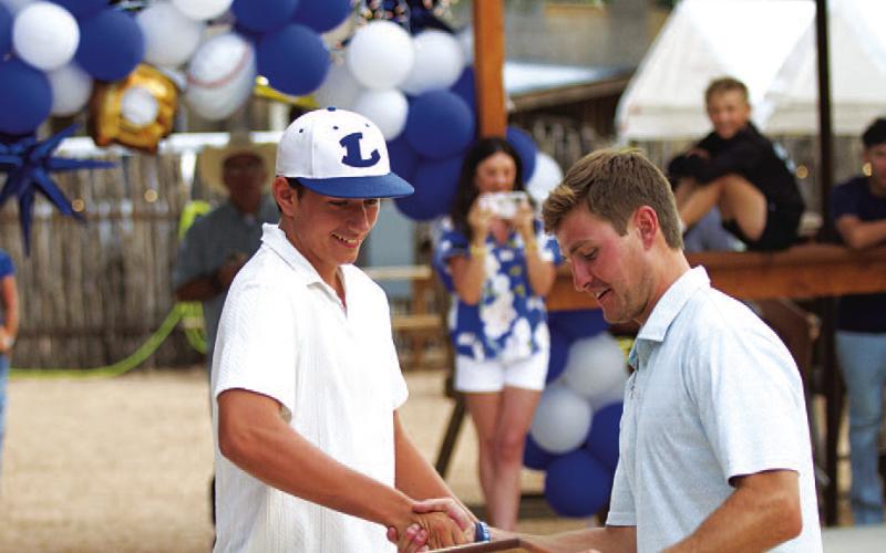 Calvin Phelps, left, receives the Pitcher of the Year award from assistant coach Hadley Berry. HUNTER KING | DISPATCH RECORD