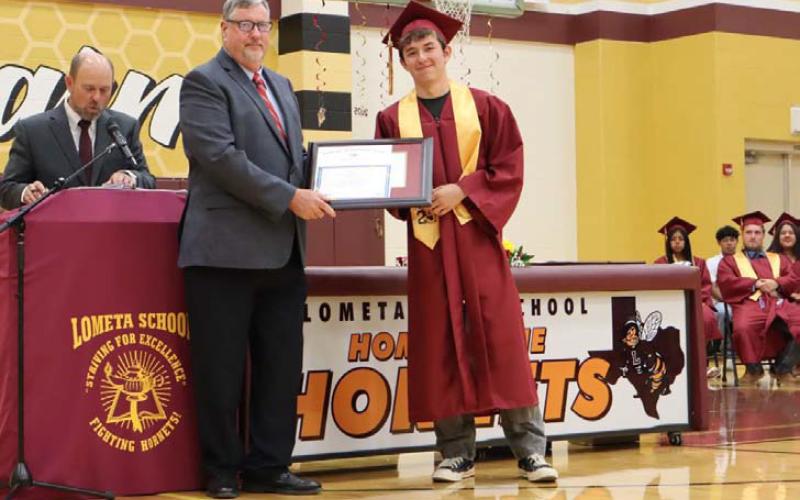 MASON HINES | DISPATCH RECORD Principal Ken Frazier, left, presents Class of 2025 valedictorian Diego Garrido with his award certificate and medal as the top-ranking graduate at Lometa High School.