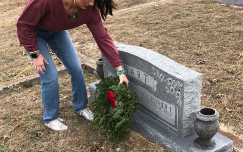 Ashton Straley places a wreath at this veteran’s grave in Smith Cemetery at School Creek. courtesy photo