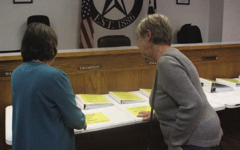 Lometa resident Cynthia Kirby, left, and Lometa City Council member Gloria Martin review the city’s breakdown of accounts on display at Monday night’s council meeting. CHERI JAY-WIENECKE | DISPATCH RECORD