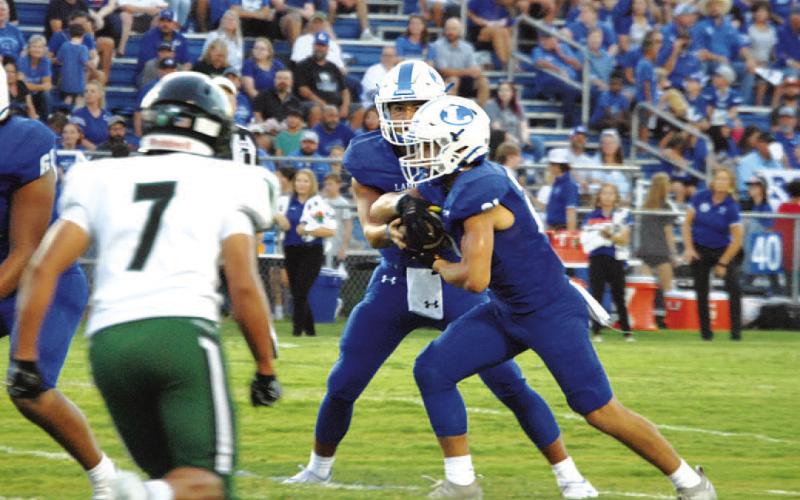 David Flores reads the Connally defensive end before handing the ball to Ethan Moreno. HUNTER KING | DISPATCH RECORD