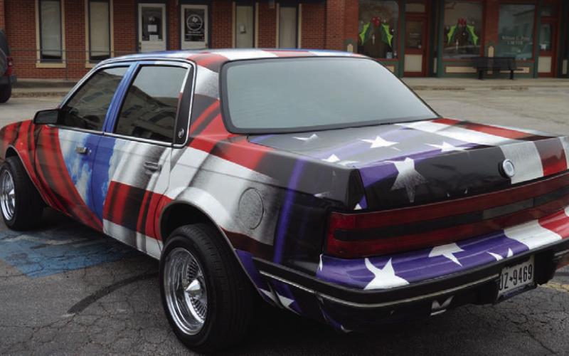 ERICK MITCHELL | DISPATCH RECORD The back half of Sanchez’s vehcile is wrapped in the Stars and Stripes of the American flag.