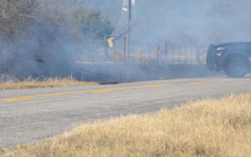 A Lampasas County Sheriff deputy drives through thick smoke during the grass fire that occurred in the county Tuesday afternoon. MONIQUE BRAND | DISPATCH RECORD