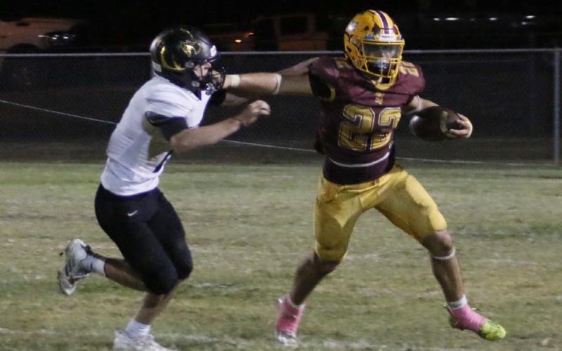 Lukas Smailus-Cruz stiff arms a defender during a run. MASON HINES | DISPATCH RECORD