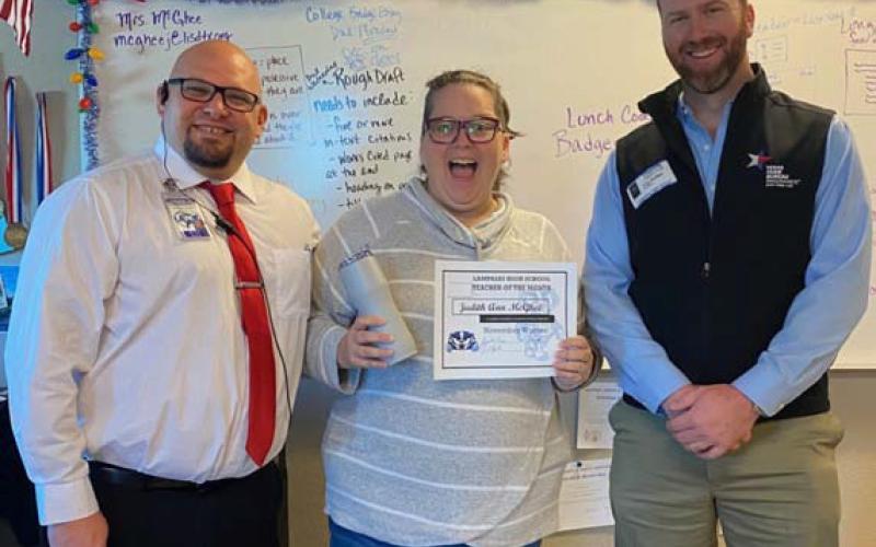 Judith Ann McGhee was recognized recently as the November Teacher of the Month at Lampasas High School. Under her direction, the UIL Academic Team is a two-time district champion. McGhee also teaches English IV. Assistant Principal Ryan Race, at left, and Clay Phillips of Farm Bureau Insurance are pictured with her. COURTESY PHOTO