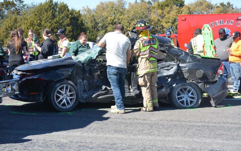 Bystanders aid first responders in reaching two teenagers involved in a fatal crash Tuesday afternoon. One of the teenagers died as a result of the collision on U.S. Highway 190. MONIQUE BRAND | DISPATCH RECORD