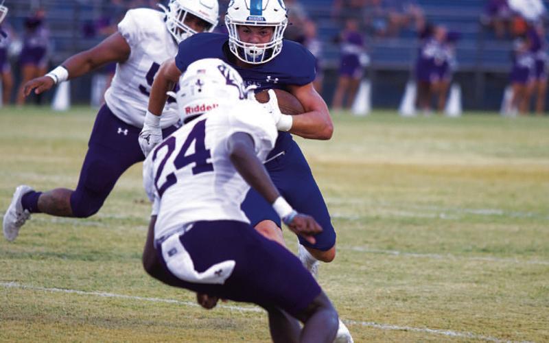 Jett Walker stares down an Elgin defender as he runs toward the end zone. HUNTER KING | DISPATCH RECORD