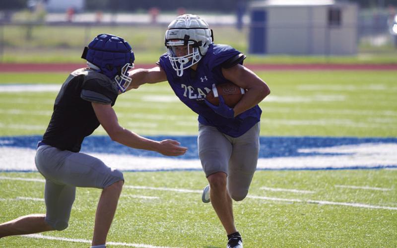 Haegan Oncken throws a stiff arm trying to make a defender miss during Saturday’s scrimmage. HUNTER KING | DISPATCH RECORD