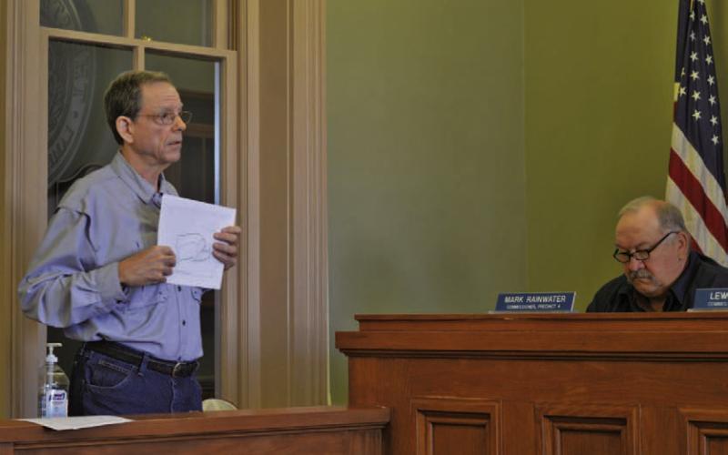 ERICK MITCHELL | DISPATCH RECORD Area resident Mike Watson, who owns property near the proposed Pitt Creek Ranch development, gives an update at Monday’s Commissioners Court meeting on the Lampasas County Municipal Utilities District #1 application that awaits approval from the Texas Commission on Environmental Quality. Also pictured, at right, is Precinct 4 Commissioner Mark Rainwater.