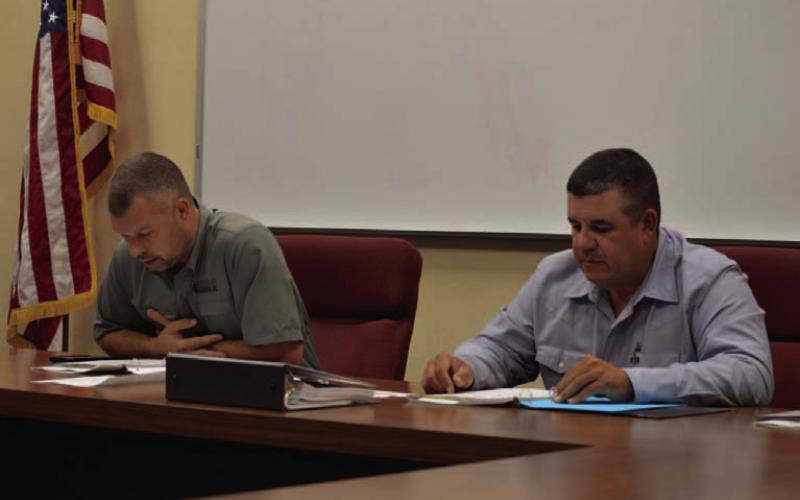 Lampasas Central Appraisal District Board of Directors chairman Marshal Brewer, at left, and board member Chris Harrison pour over budget numbers proposed for the 2026 fiscal year. ERICK MITCHELL | DISPATCH RECORD