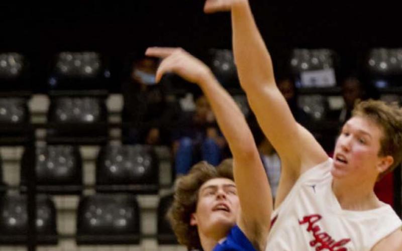 Landon Mulcahy, left, tips off against 6’7” Argyle senior Nate Atwood in the area championship, which Argyle won 65-45. JEFF LOWE | DISPATCH RECORD