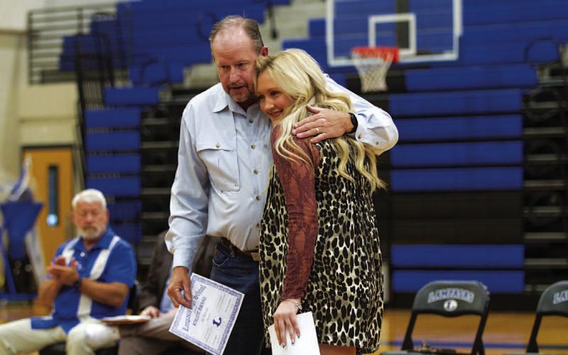 Keaton Owen gets a hug from assistant coach Doug Messer after getting her award. HUNTER KING | DISPATCH RECORD