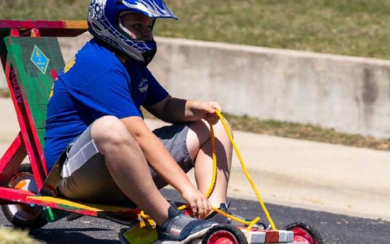 Braydon Lancaster, Pack 100 Webelo Den, reaches for the brakes as he nears the finish line of the Downhill Derby. JEROMIAH LIZAMA | DISPATCH RECORD