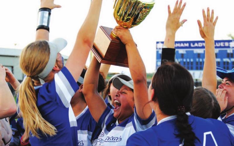 Mia Maldonado holds the trophy over her head surrounded by her teammates last Friday night. HUNTER KING | DISPATCH RECORD