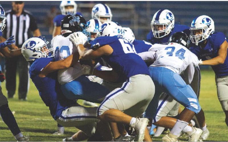 HUNTER KING | DISPATCH RECORD Raider Morua, left, and Nick Torrez are in on the tackle of the Northeast ballcarrier.