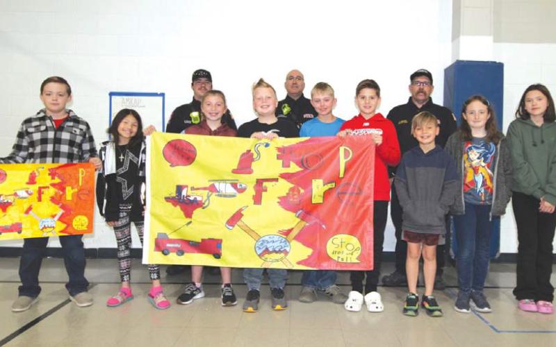 Fifth-grade flag design winners from Hanna Springs Elementary School are, front row from left, Ryder Hill, Kaydence Staab, James Hesselbacher, Holley Wakeman, Austin Flick, Hadley Khul-Gosnell, Cutter Sellers, Megan Cross and Zoee Booth. Their teacher is Tyler Coonrod. On back row are Lampasas Fire Marshal JP Harris, Capt. Colton Baker and Deputy Chief Corey Greiner. JOYCESARAH MCCABE | DISPATCH RECORD