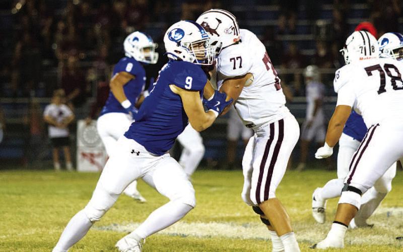 Brady Renfrew tries to shed the block of a Lion offensive lineman. HUNTER KING | DISPATCH RECORD