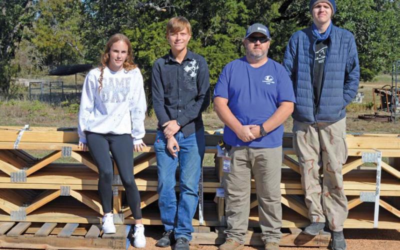 Standing next to materials earmarked for the tiny home project are, from left to right, Amber Beuermann, Thomas Cox, CTE teacher Richard Silva-Brown and Ethan Sanders. The students are all involved in Lampasas High School’s construction program. Erick mitchell | dispatch record