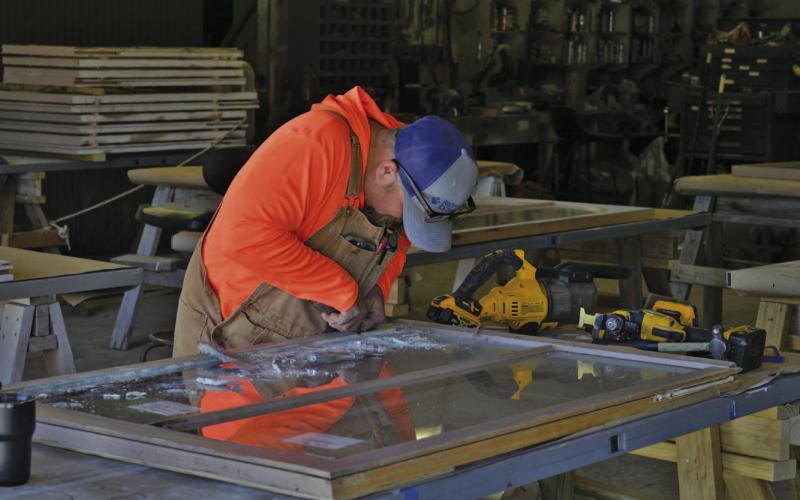 ERICK MITCHELL | DISPATCH RECORD Adam Morrison of RKJ Construction works on one of the downstairs courthouse windows. The windows are being removed in sections and taken off-premises for reglazing.