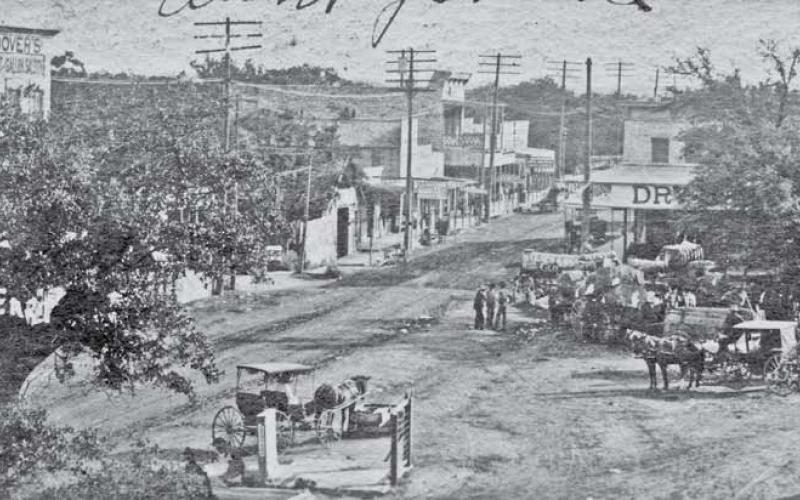 COURTESY OF JEFF JACKSON | POSTCARD PHOTO BY WARD Bird’s-eye view of the northeast corner of the public square. Hoover’s Quart &amp;amp; Gallon Saloon was located in the Hanna Building on the north side of the square. Its sign can be seen just above the treetops to the left.