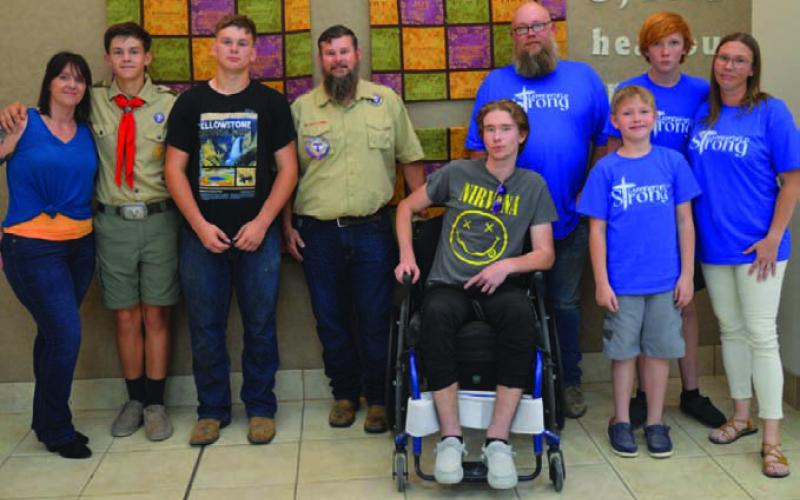 Trent Royar, second from left, has earned the Boy Scouts of America Heroism Award. He is joined by his parents, Cassie and Paul, along with brother Ethan. The Royar family is pictured with the Sappenfields -- from left to right, Hunter, Chad, Luke, Wyatt and Brandie Sappenfield. ERICK MITCHELL | DISPATCH RECORD