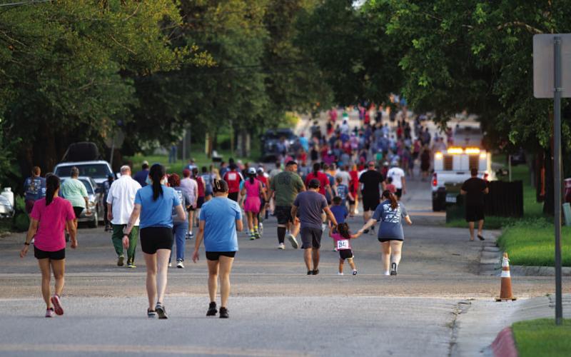 Runners and walkers head down the road during the race.