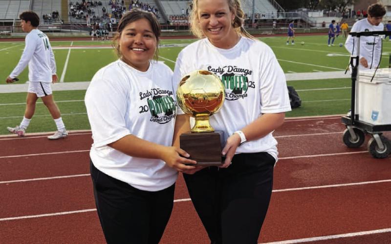 Kim Burnside, at right, shows off a trophy from a playoff win while at Burnet. COURTESY PHOTO