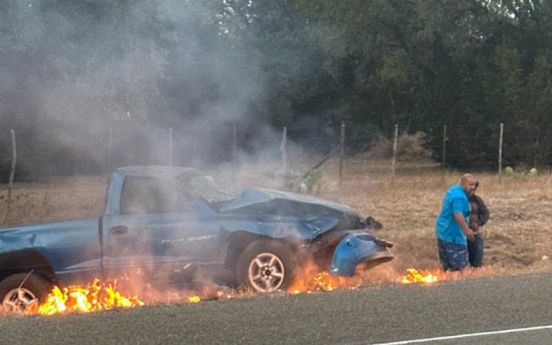 Brandon Roedler helps get a man to safety after he was trapped in a burning vehicle Sunday morning just outside of Burnet on Hoover Valley Road. COURTESY PHOTO
