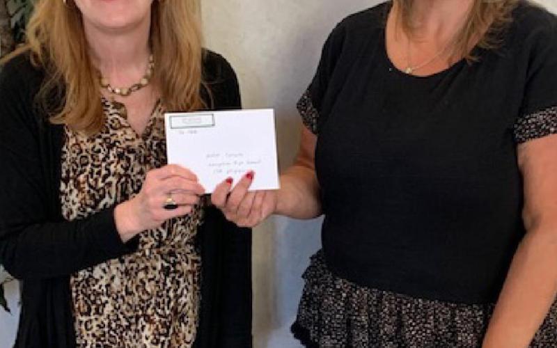 Julie Salvato, coordinator of Career and Technical Education for the Lampasas school district, accepts a check from ’36 Club President Danielle Shepard. COURTESY PHOTO