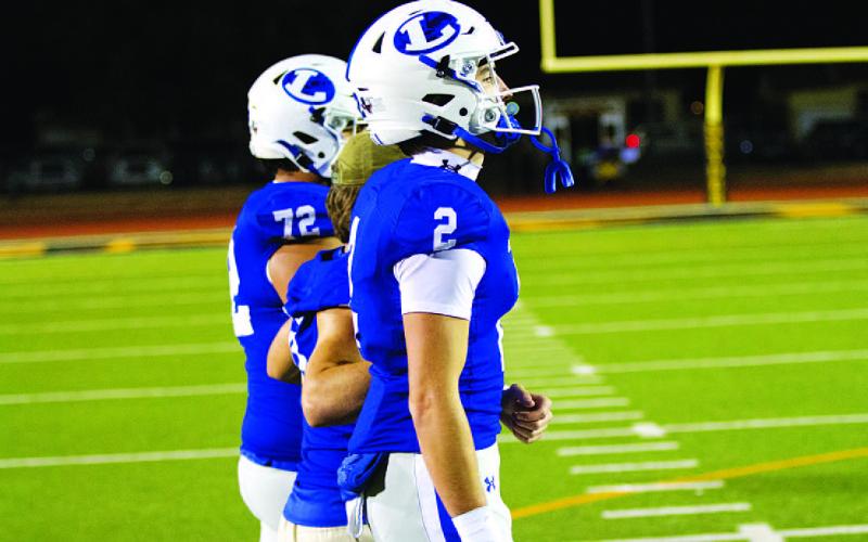 HUNTER KING | DISPATCH RECORD Bryson Roberts and his fellow captains head out for the coin toss last Friday.