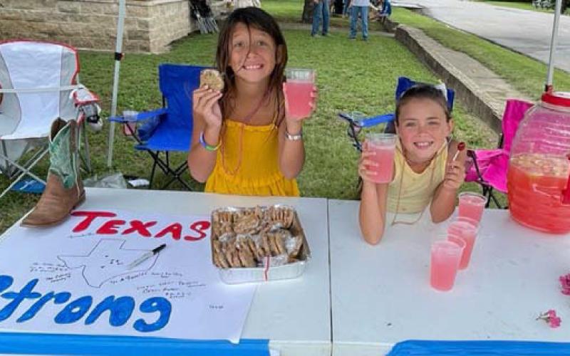 Lucy and Aspyn Shelton offered homemade cookies and lemonade to Spring Ho parade attendees last week in exchange for donations that will be forwarded to a Hill Country family who has suffered loss due to the July 4 flooding in Central Texas. courtesy photo