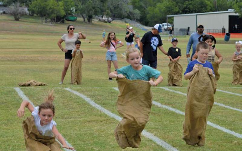 Children try their best to maintain balance during sack races at Kids’ Day Activities hosted by the Lampasas Boys and Girls Club. ERICK MITCHELL | DISPATCH RECORD