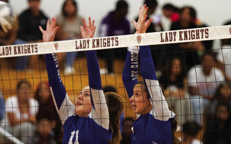 Ava Dowdy, left, and Landry White jump for a block in Harker Heights on Tuesday. HUNTER KING | DISPATCH RECORD