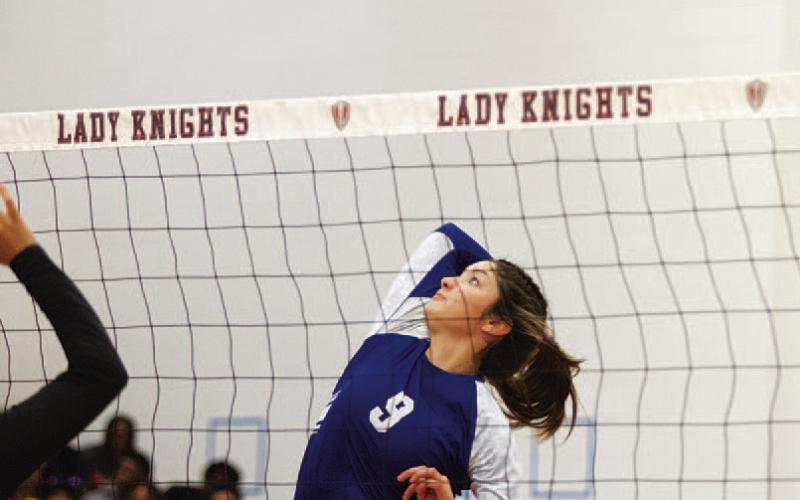 Lilee Hamill rises up to spike the ball against the Lady Knights. HUNTER KING | DISPATCH RECORD