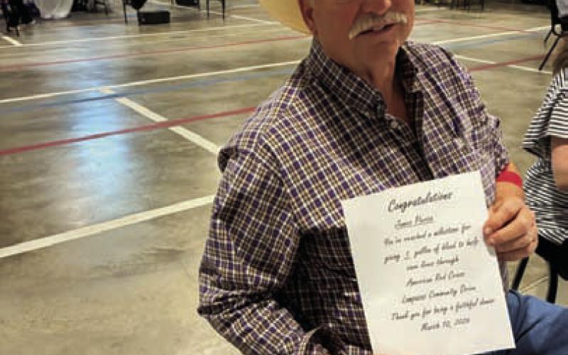 James Pierce shows his certificate for having reached the one-gallon donation level. COURTESY PHOTO