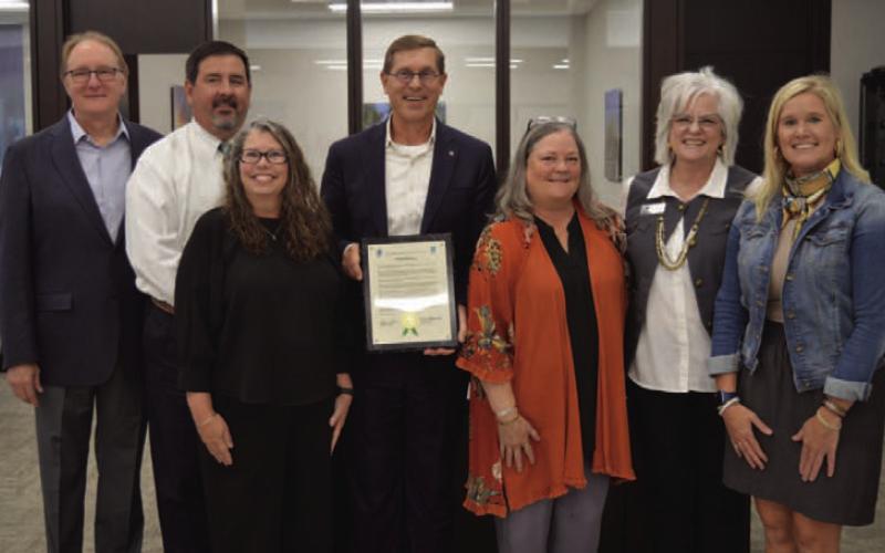 First Texas Bank of Lampasas officers, left to right, Barry Haag , Lee Loeffler, Pam Hunter, Kelvin Barkowsky, Donna Roberts, Ladonna Bishop and Annie Trotter pose with a resolution plaque celebrating 140 years of business in Lampasas. ERICK MITCHELL | DISPATCH RECORD