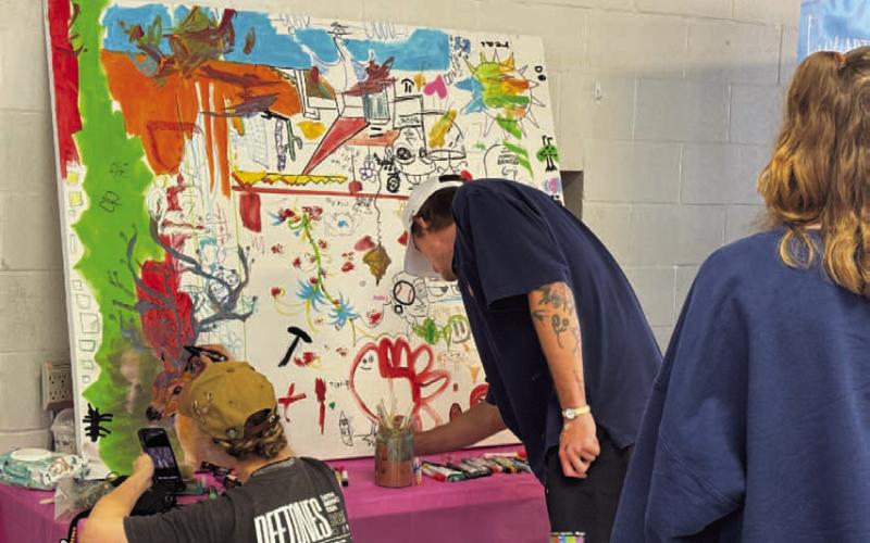 ADAM BARRIOS | DISPATCH RECORD Community members added their touches to an art board at the Arts in the Park for Kids festival on Saturday. The festival was moved to the old Lampasas Middle School cafeteria on Western Avenue due to weather concerns but still saw a great turnout.