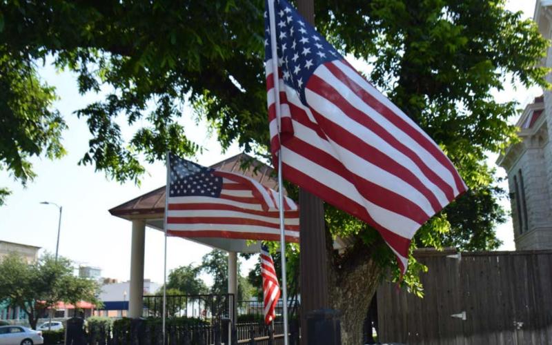 The stars and stripes of the U.S. flag blow in the breeze around the Lampasas County Courthouse last year on Flag Day. FILE PHOTO