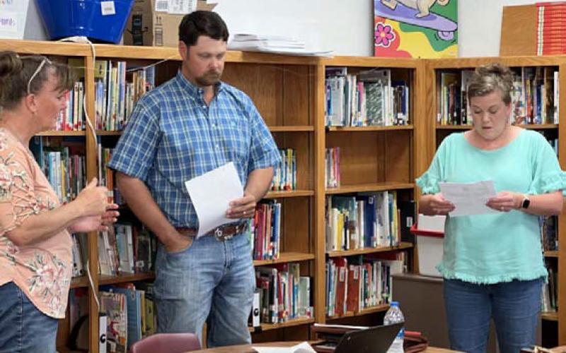 Lometa ISD Business Manager Ronda Bridges, left, administers the oath of office to school board trustees Dusty Duncan and Cristopher Brister. MASON HINES | DISPATCH RECORD