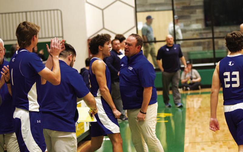Head coach Aaron Nuckles and Tripp Stinnett celebrate after the final buzzer. HUNTER KING | DISPATCH RECORD