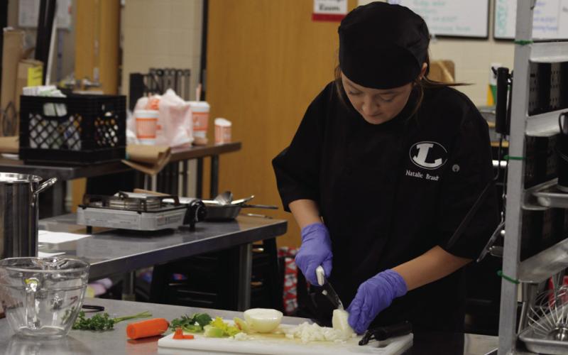 Natalie Braudt dices some onion during class on Nov. 21. ERICK MITCHELL | DISPATCH RECORD