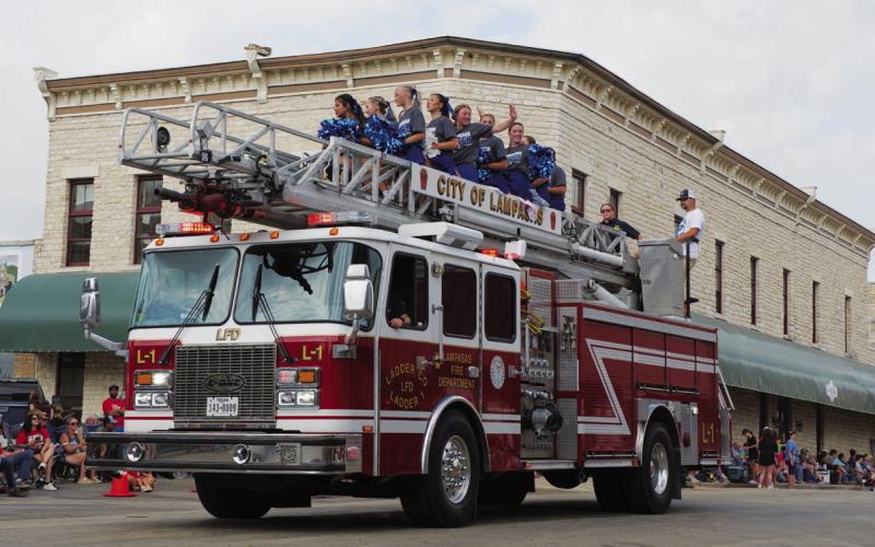 Lampasas High School cheerleaders wave to the crowd atop a Lampasas Fire Department engine during Saturday’s 53rd annual Spring Ho Grand Parade. ADAM BARRIOS | DISPATCH RECORD