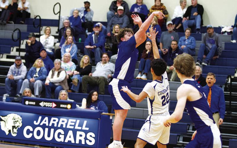 Aidan Nuckles shoots over a Cougar defender in the first half of Tuesday’s game. HUNTER KING | DISPATCH RECORD