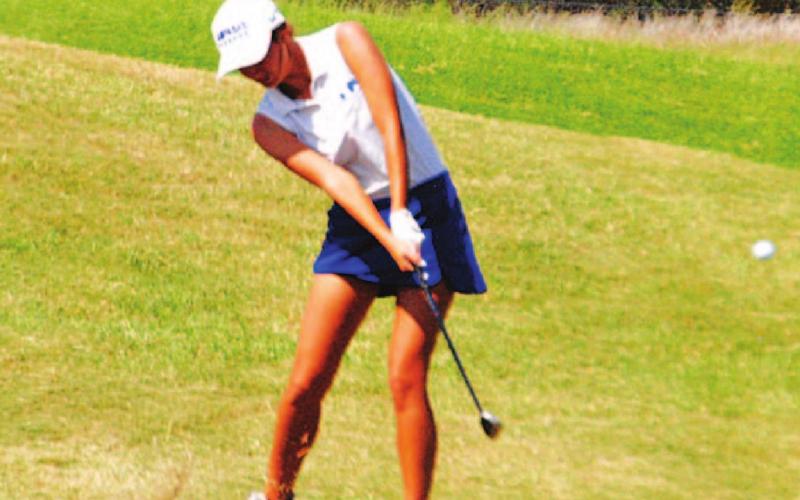 Shaylee Wolfe makes contact with a pitch shot during the state golf tournament on Tuesday. HUNTER KING | DISPATCH RECORD