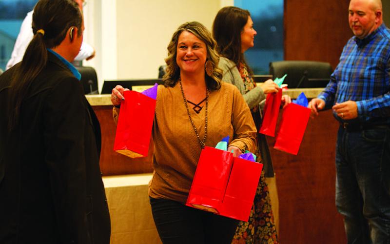 City Secretary Becky Sims, center, and City Manager Erin Corbell distribute gift bags to council members Zachary Morris, left, and Davis Keele. The bags contain a commemorative coin given to each member annually in appreciation for their service rendered to the city. HUNTER KING | DISPATCH RECORD