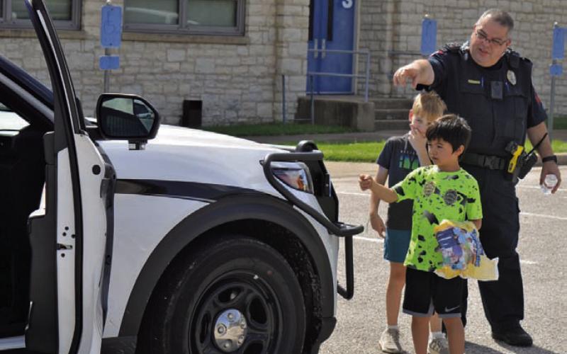 Lampasas Police Department Patrol Sgt. Steve Sheldon shows children around a police vehicle during the Lampasas County Higher Education Center’s “Case of the Missing Mascot” class on Monday. ERICK MITCHELL | DISPATCH RECORD